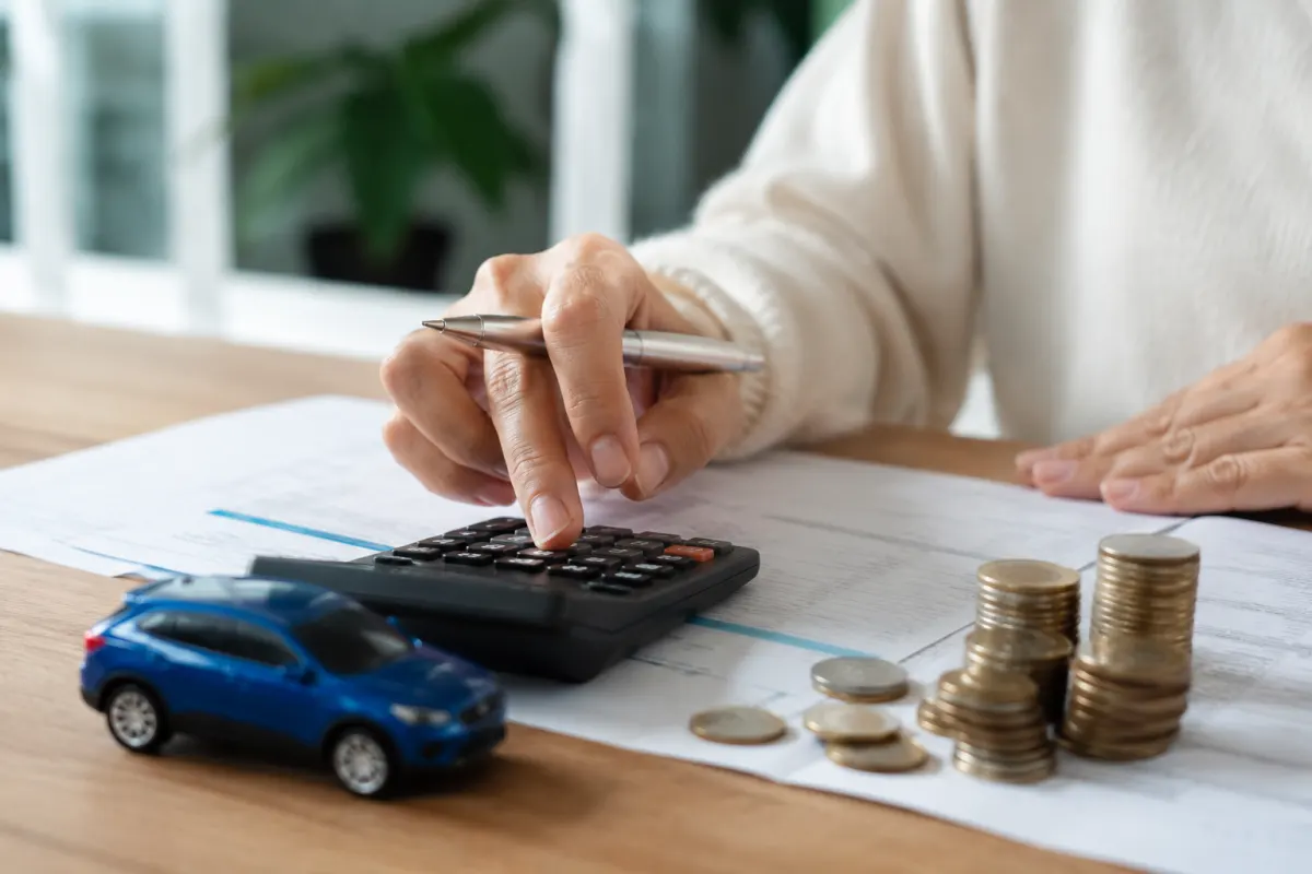 Aides pour l'achat d'une voiture électrique : ce que vous pouvez vraiment économiser Gros plan sur une prise de recharge branchée sur le flanc d'une voiture électrique blanche