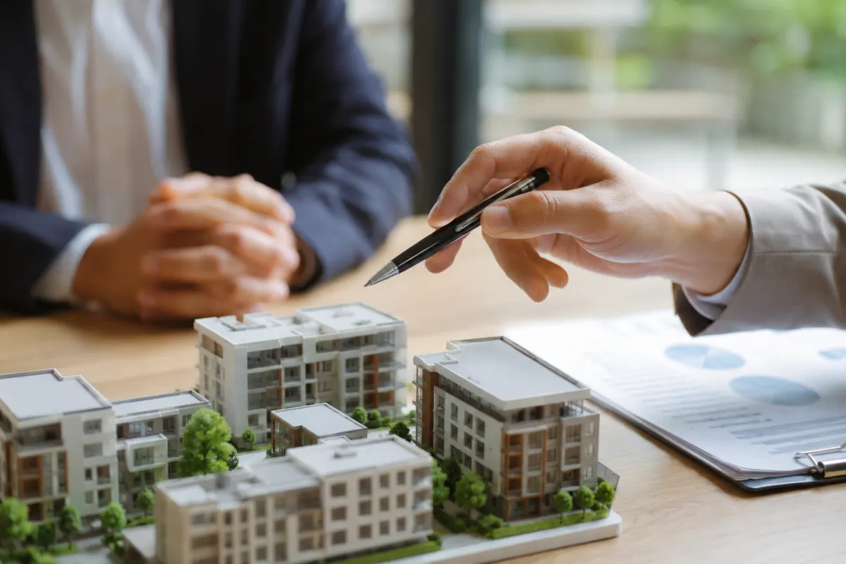 Gros plan sur la signature au stylo plume d'un contrat de co-investissement immobilier professionnel